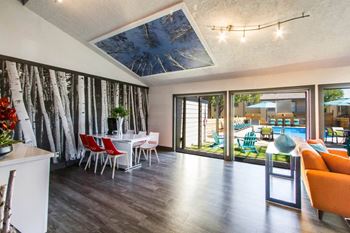 A living room and dining room with a table and chairs and sliding glass doors